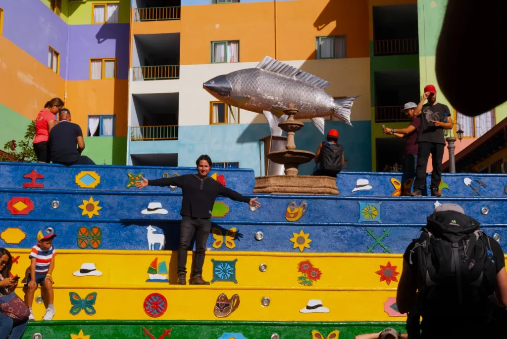Painted zócalo steps and a fish-shaped fountain in a Guatapé plaza